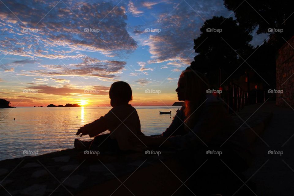 Toddler enjoying colorful sunset by water