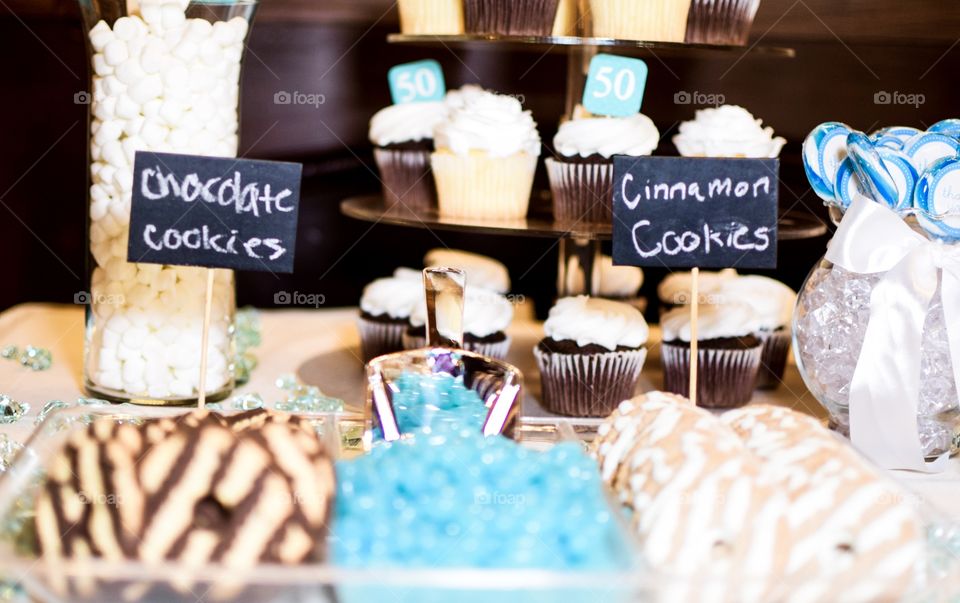 Two kinds of cookies, candy and cupcakes at a “sweets “ table