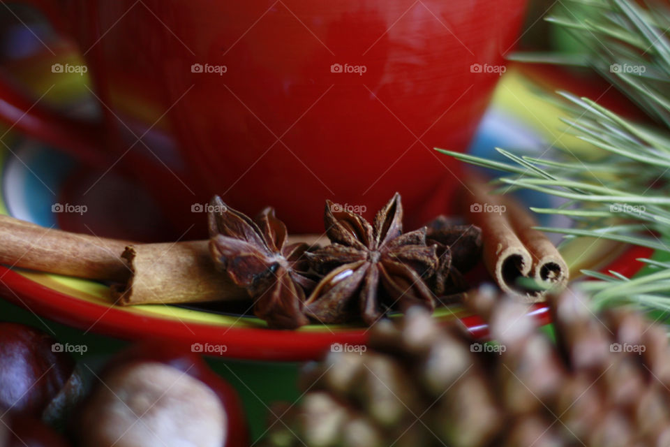 Red coffee cup, cinnamon and anise stars, close up