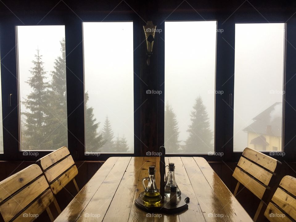 Rustic restaurant with fog and trees seen out of the windows