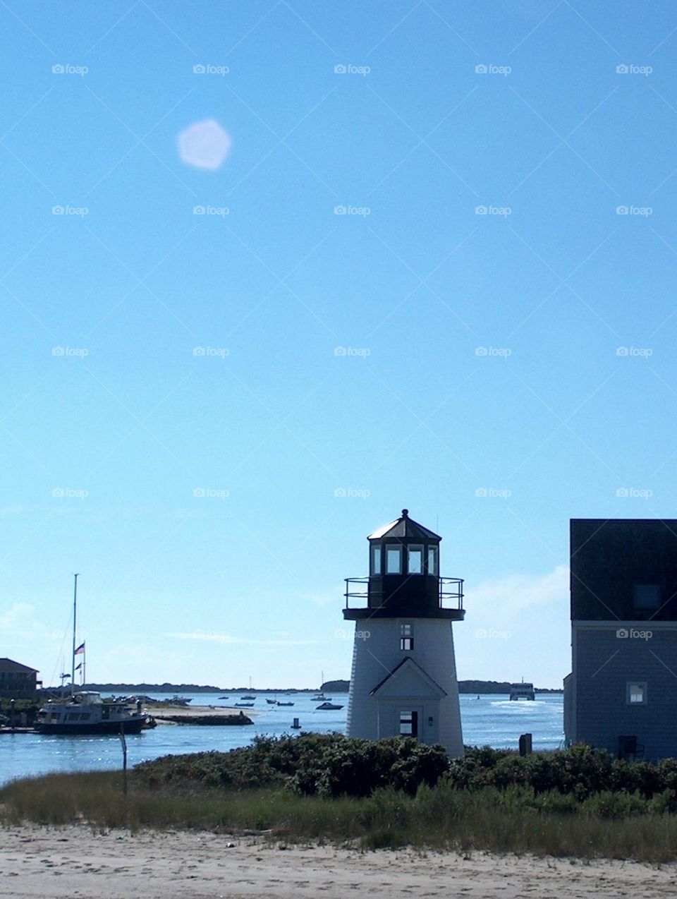 Moon above the lighthouse on the bay 