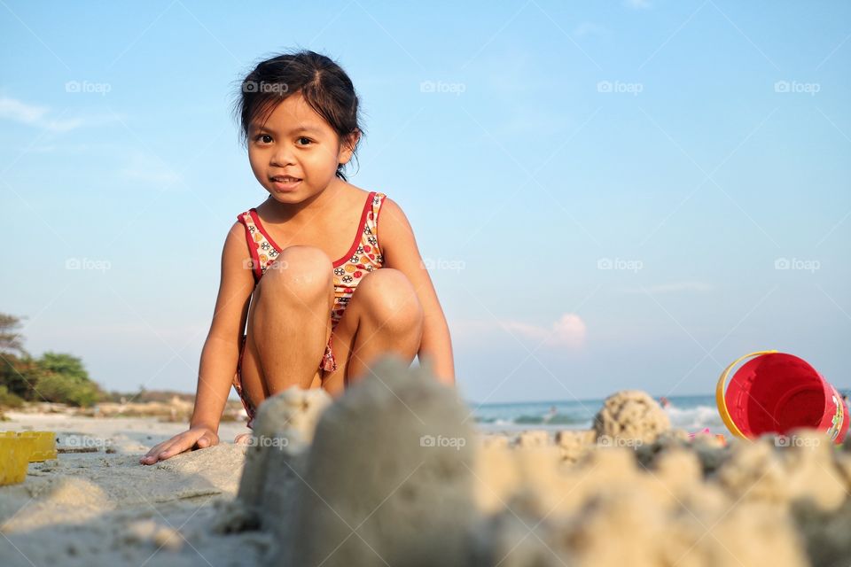 the girl playing the sand on the beach in the morning.