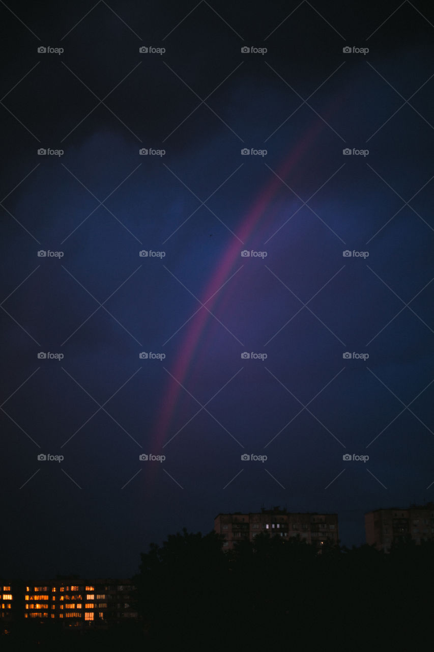 night photo of cities after rain with rainbow