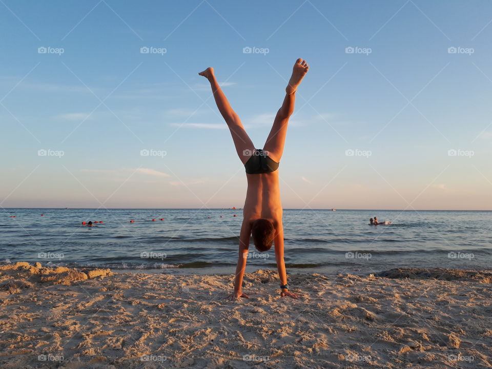 Boy doing handstand at the beach