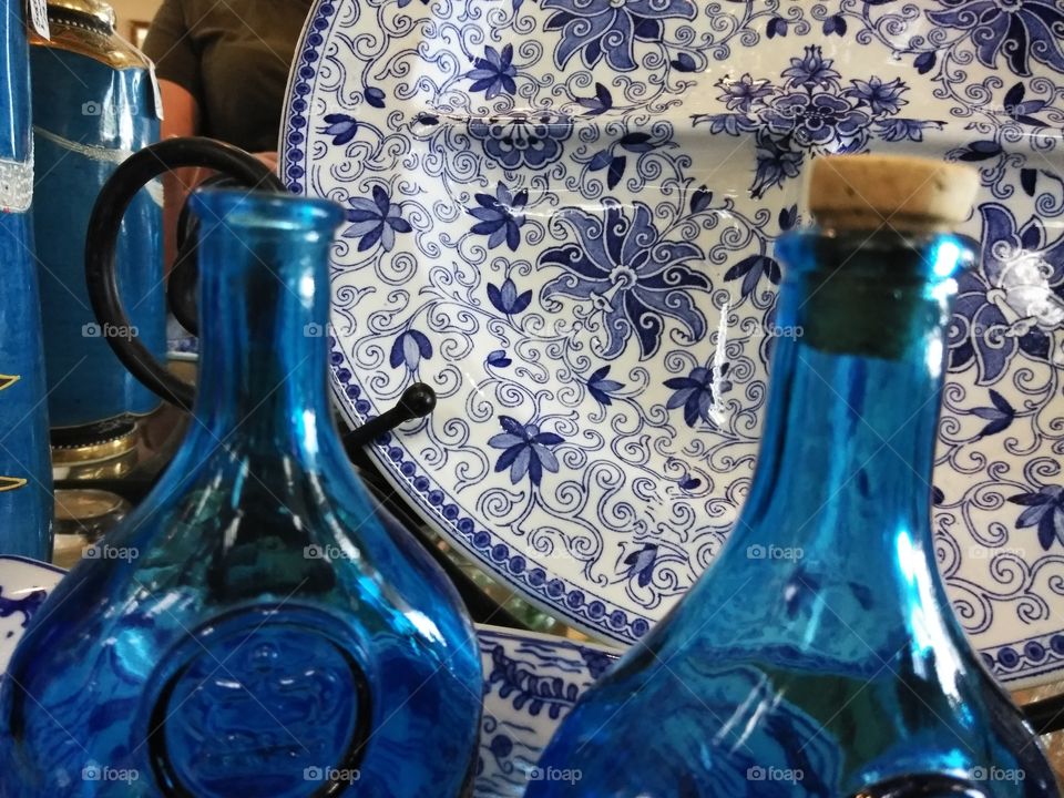 The old colbalt bottles accents the intricate detail on the antique dinner plate behind.