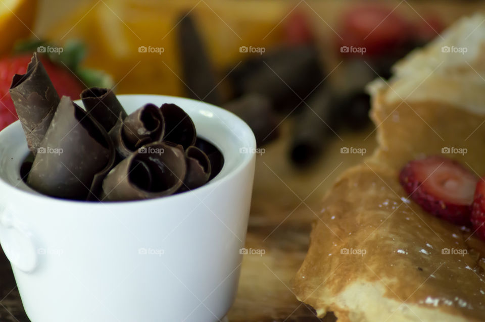 Dark chocolate rich in antioxidant ingredient on wood kitchen table with crepes and strawberry conceptual making brunch or breakfast food photography 