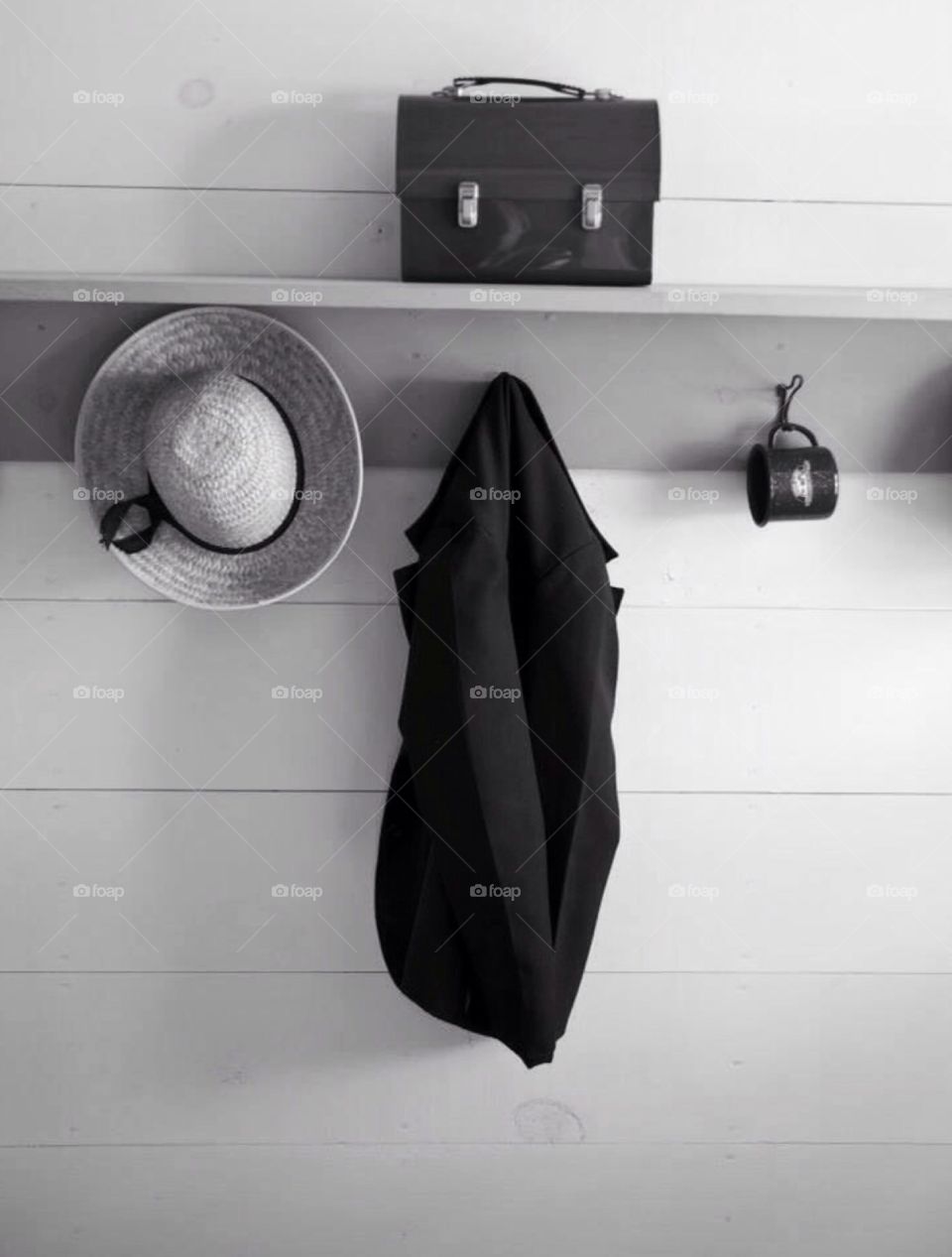 Amish living. Amish entrance way into a home , a hat , cup and lunch box hang on a wall.