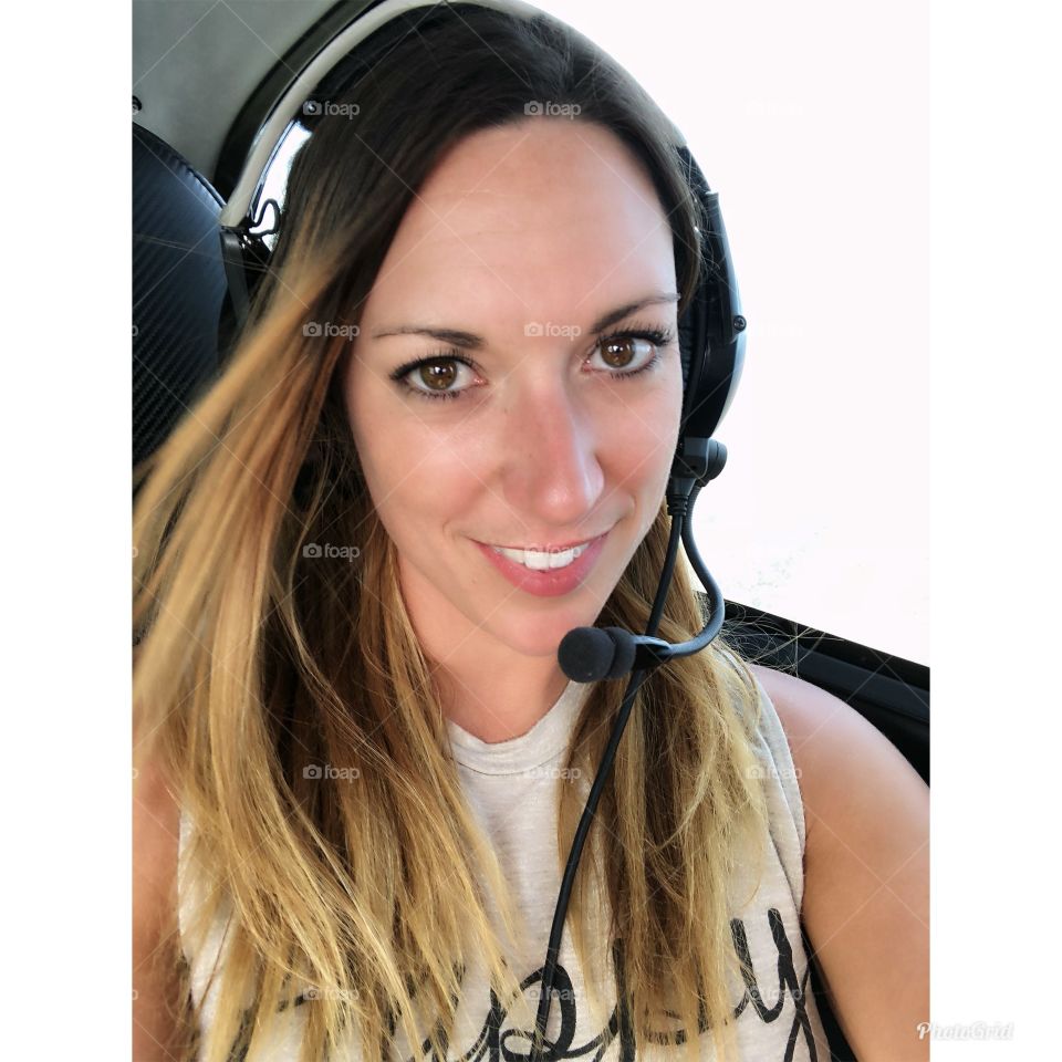 Young woman in an airplane wearing a headset