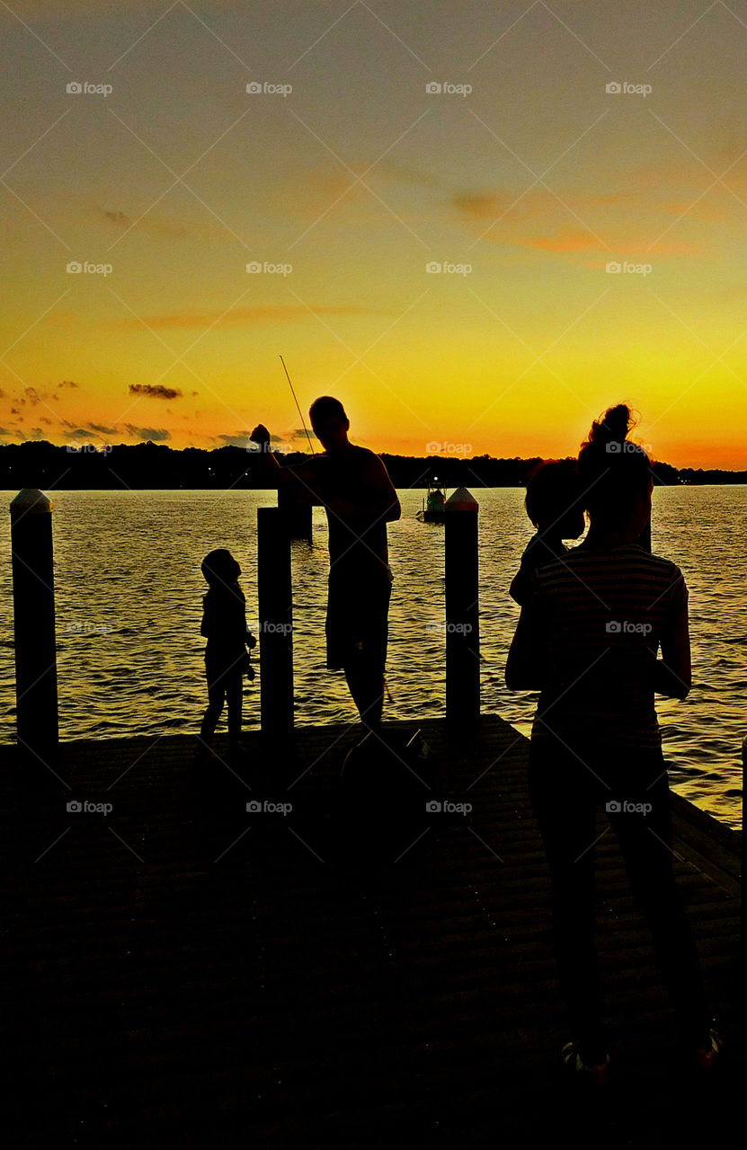 Family standing on the pier enjoying the sunset!