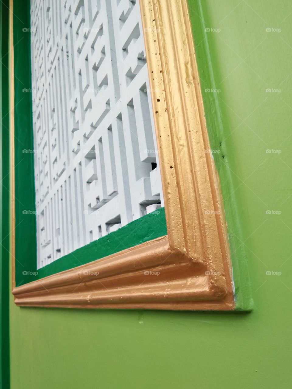 building exterior of green wall with golden frame