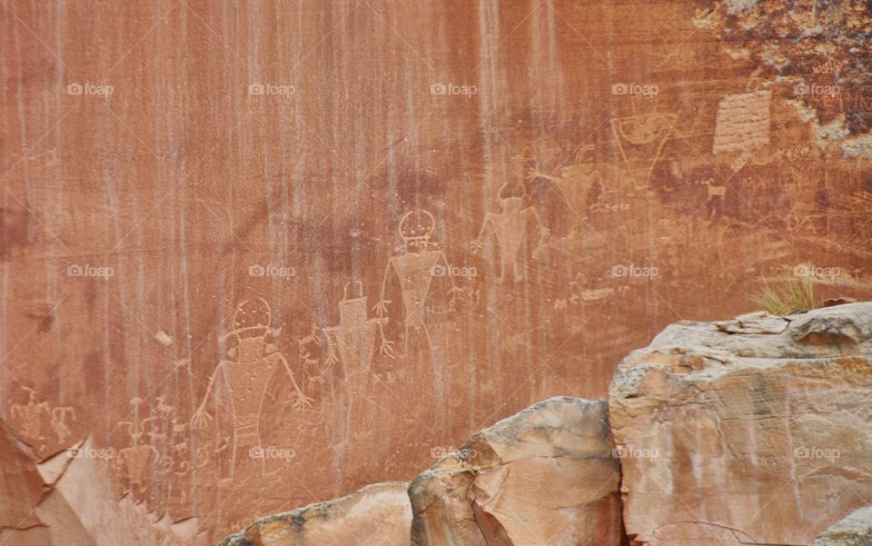 Petroglyphs from the ancients catch the eye in this shot from Capitol Reef National Park. The landscape is dry and rugged.
