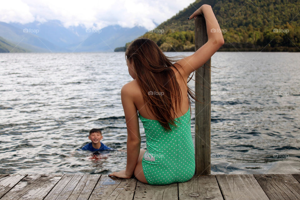 Asian woman sitting on pier over the lake