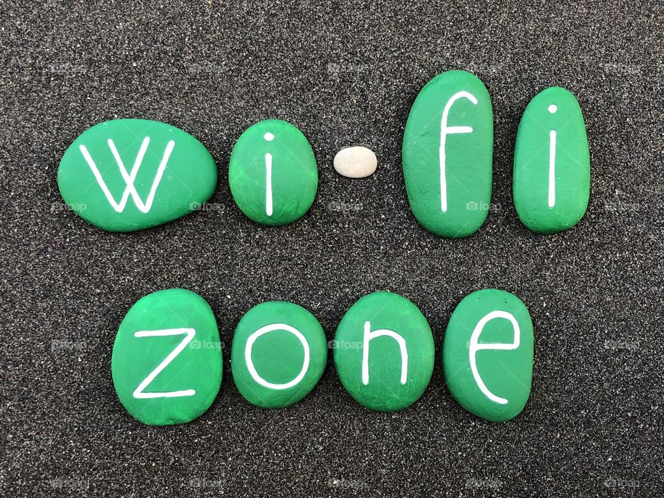 Wi-Fi Zone, logo type composition with green painted stones over black volcanic sand
