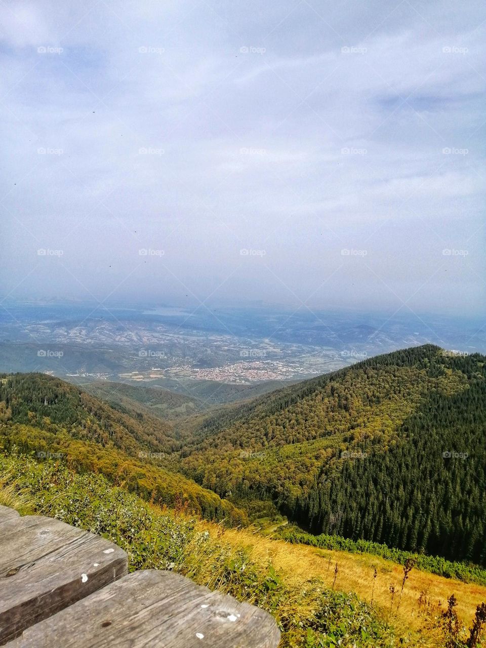 A beautiful view from high in the bulgarian mountains with colourful hills and a city beating visible beneath