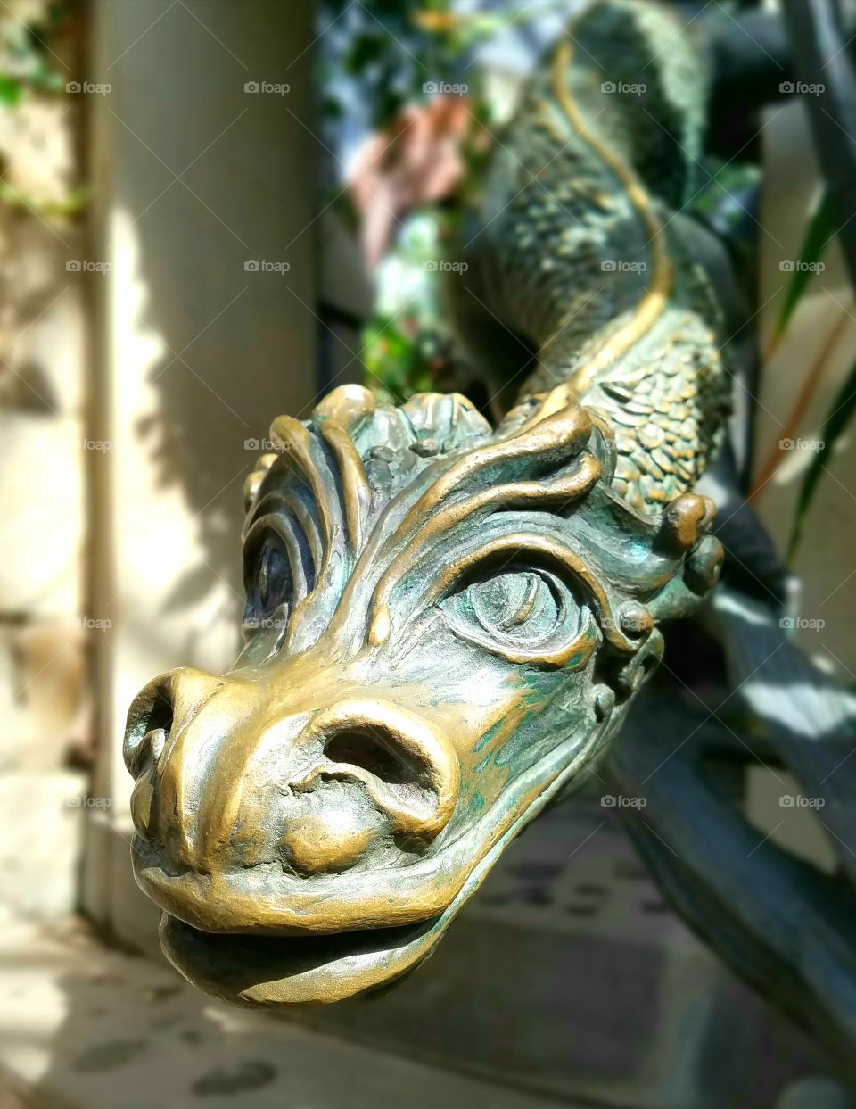 close-up of dragon head stair railing, copper/bronze sculpture