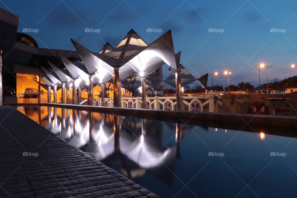 Maritime museum, reflection of the structure’s light on a pool with the mixed golden hour color...