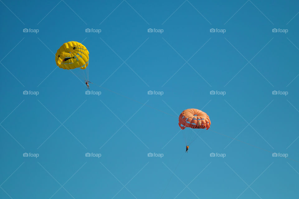 Parachutes on clear blue sky