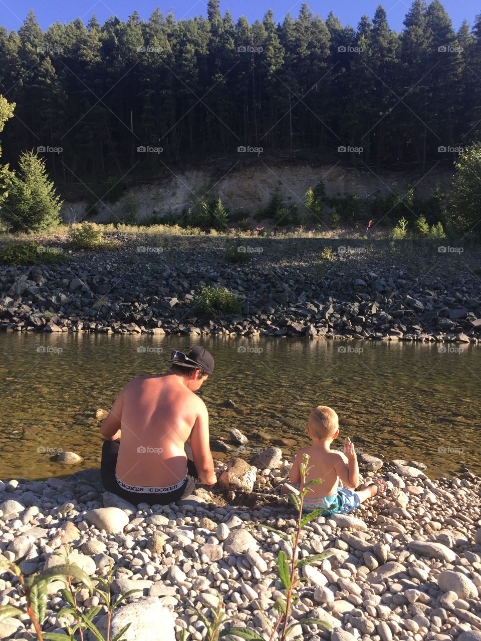 Boys throwing rocks in the river