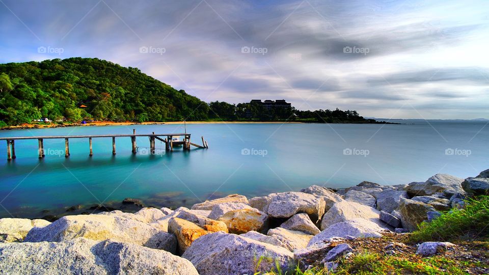 Wooden bridge at Rayong beach and beautiful sunlight with cloud 