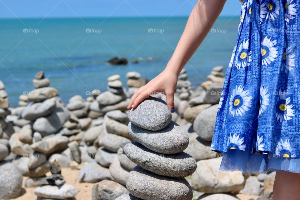 Girl building a tower from stones found on the beach