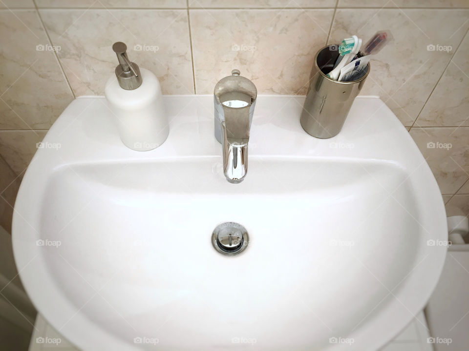 White sink with personal hygiene tools 