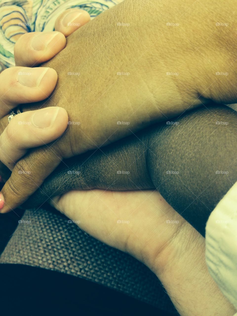 Colorful Family. A mother and father of different races hold the hand of their adopted son