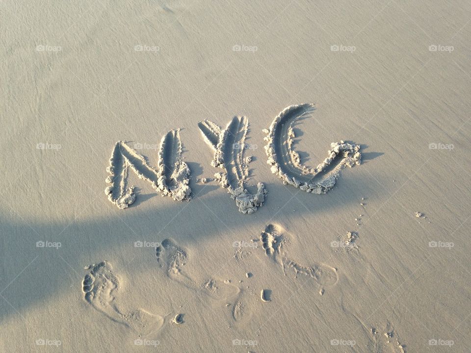 Inscription of NYC on sand