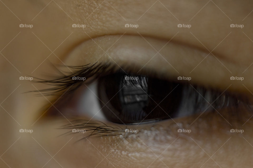 macro close up of deep black eye almond shape of a young Asian boy