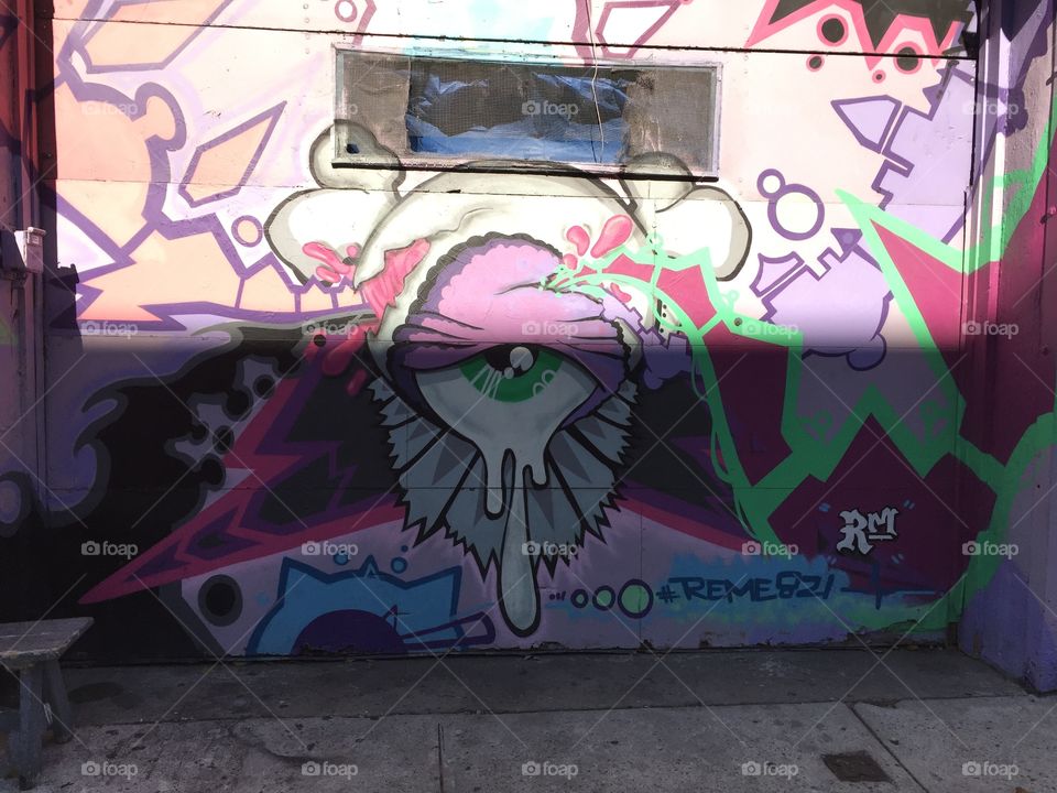 Photo of graffiti on a Brooklyn building . The photo depicts a slime eyeball with unique detail and styling .