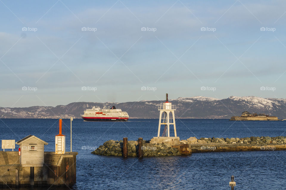 Ship passing near a lighthouse in Trondheim, Norway 