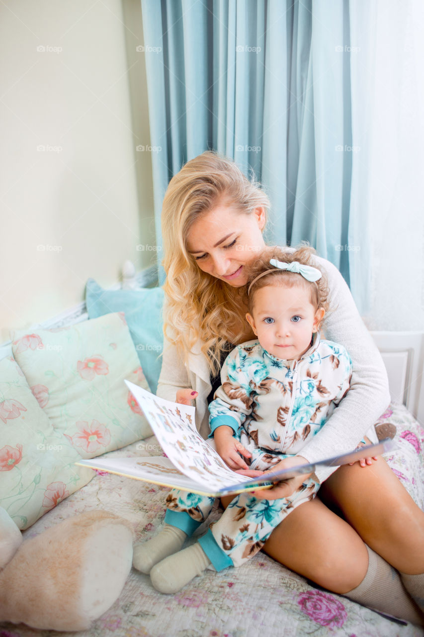 Mother with daughter reading a book