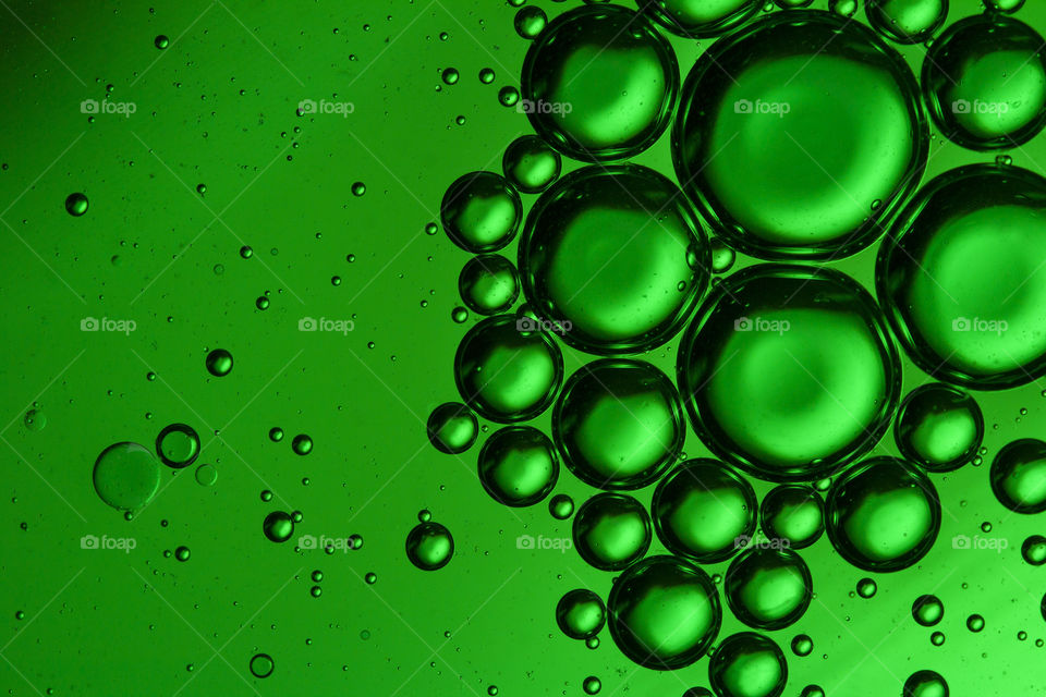 Abstract background of green oil bubbles on water surface