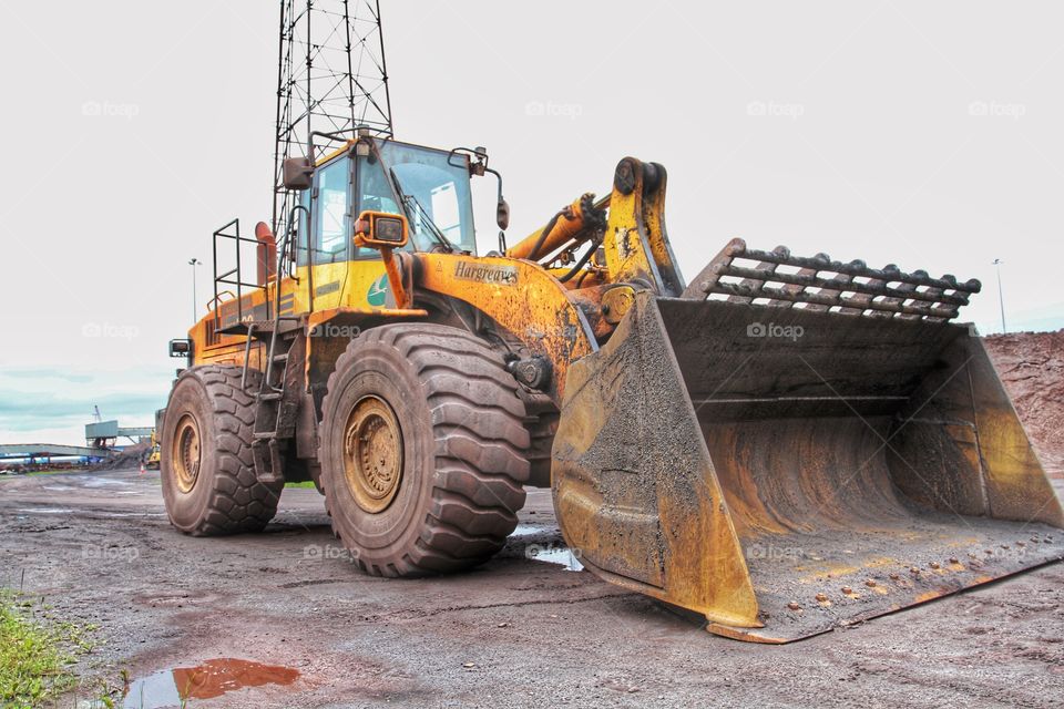 A large, JCB or digger in an industrial environment.