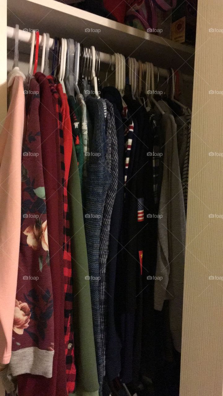 Hanging clothes in closet in color order
