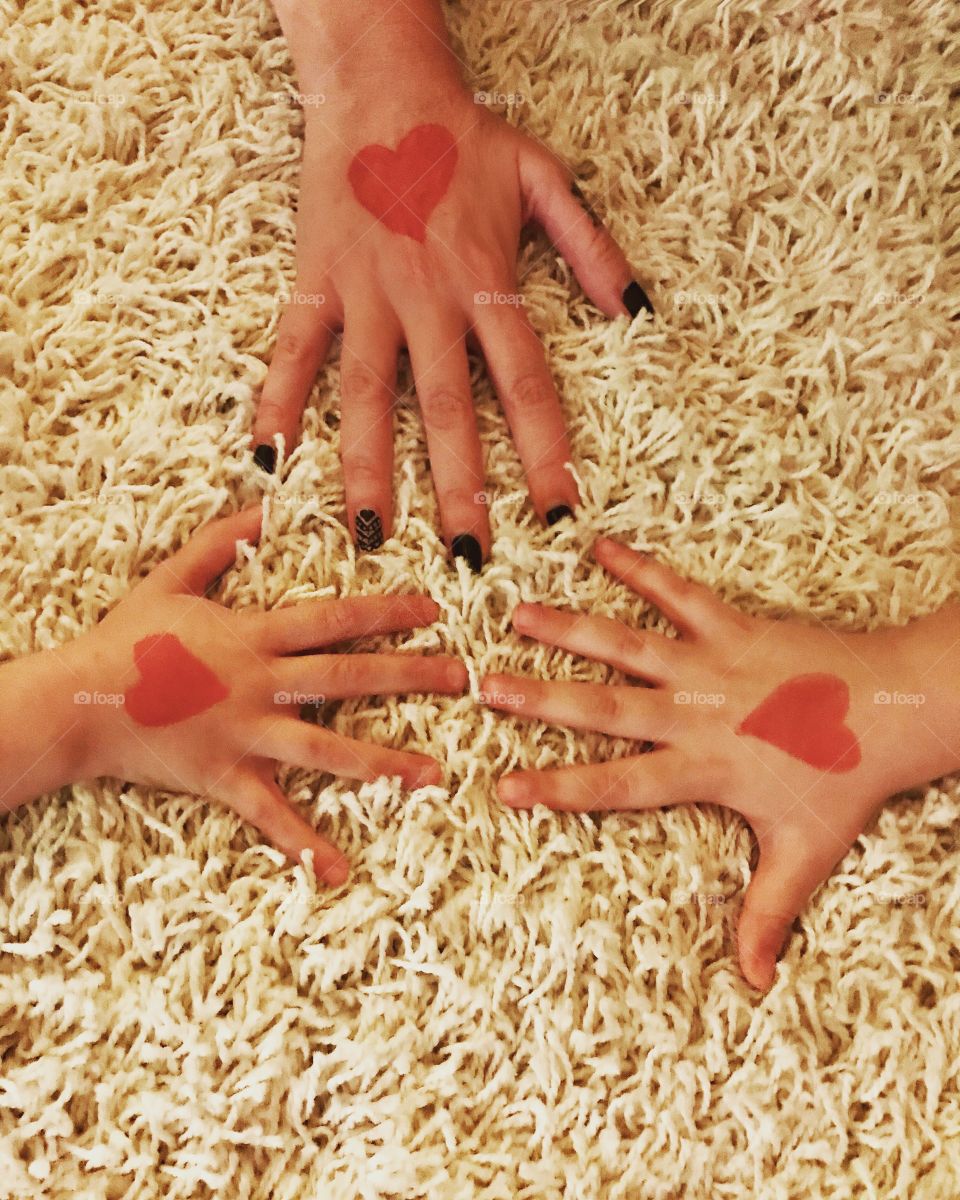 Mommy daughter and son’s hands with a red heart