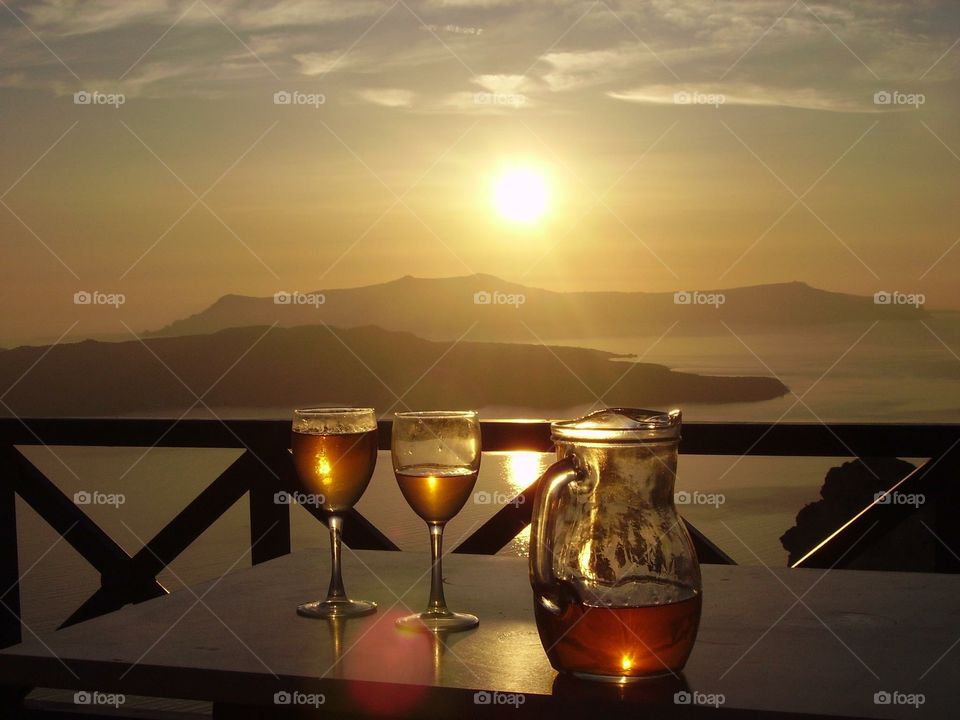 Wine on balcony overlooking sea at sunset 