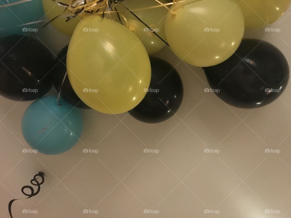 I display of colorful yellow ,  Black and blue birthday balloons getting ready to celebrate a sweet 16 birthday party located in America, USA