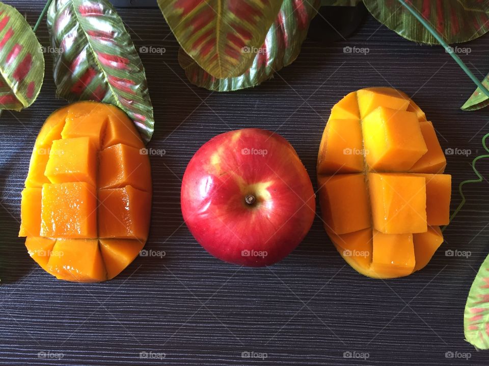 Mango and apple on grey wooden background 