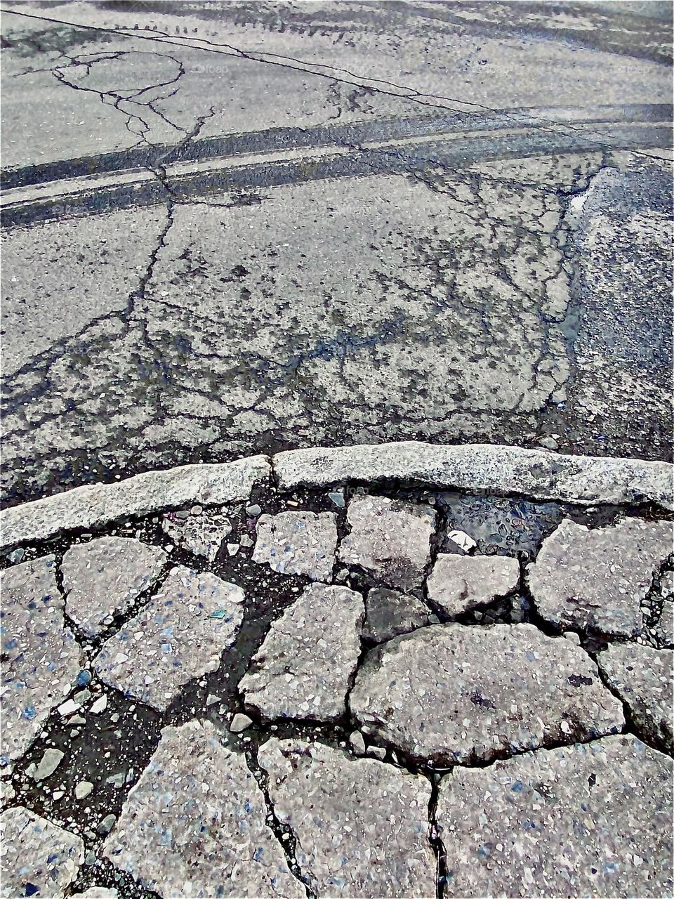 A curvy sidewalk by the train tracks & the parking lot under the Pulaski Bridge in Queens, NY was gradually broken down by the elements to give it the appearance of a historic site. The minimal pattern is quite interesting. 2021. Hypnotic Productions