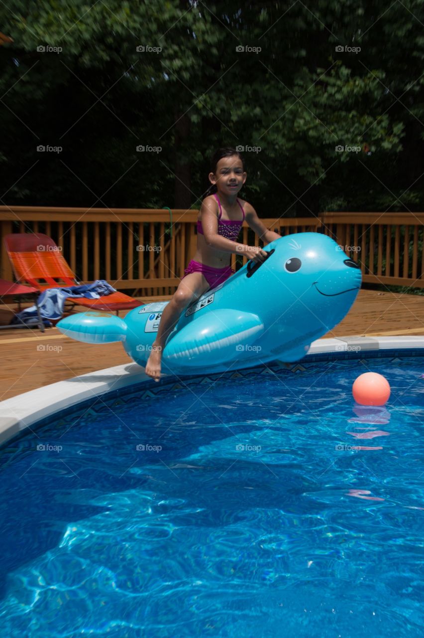 Jumping on the inflated dolphin from the side into the pool