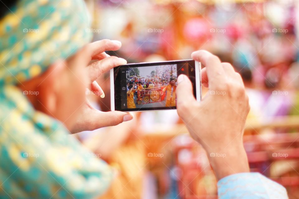 Photographers are using mobile phones to take pictures of colorful parades. Exciting to tourists who have seen He is trying to take the best picture out. Love photography.