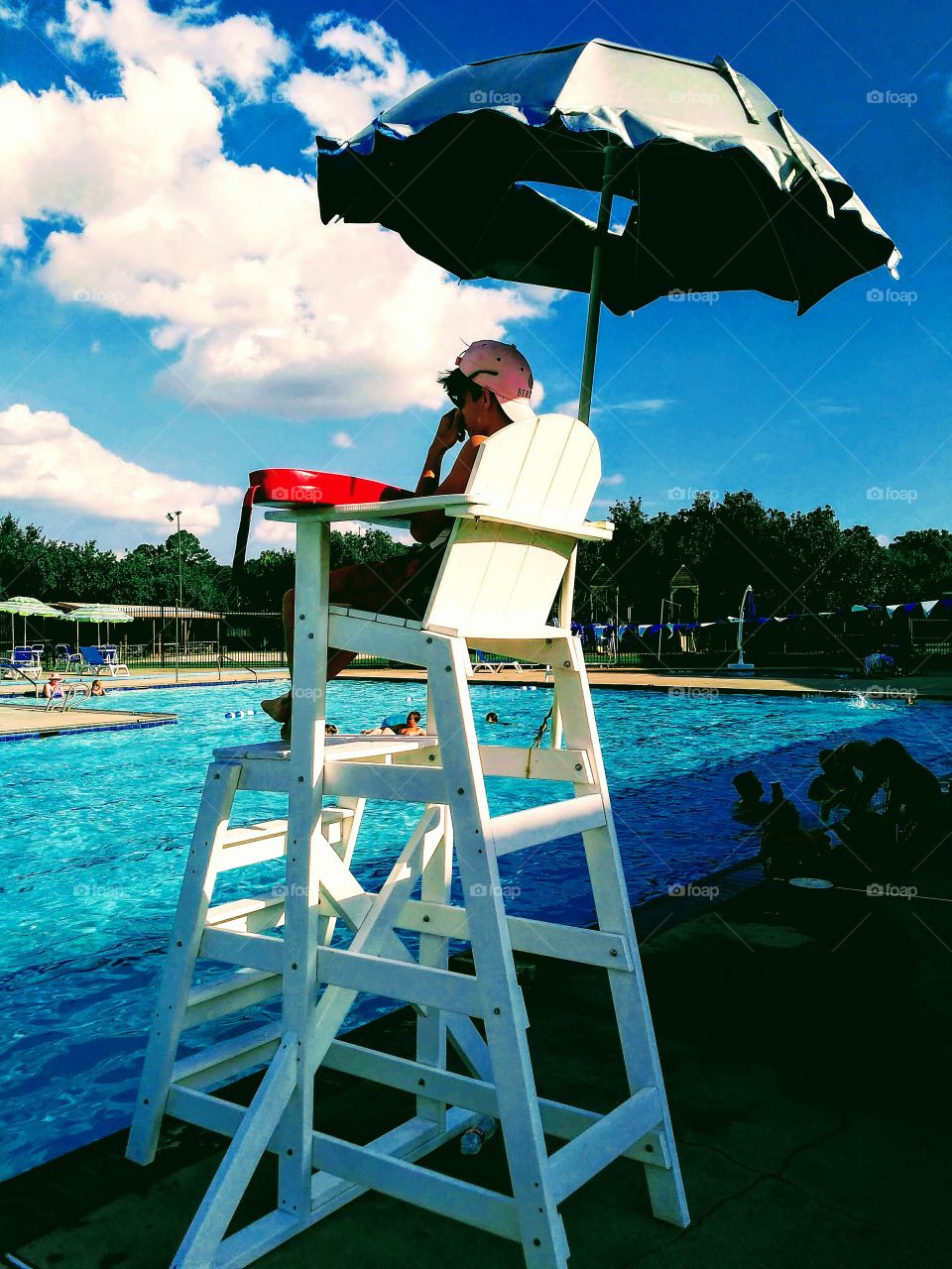 Lifeguard supervising children swimming at the pool.