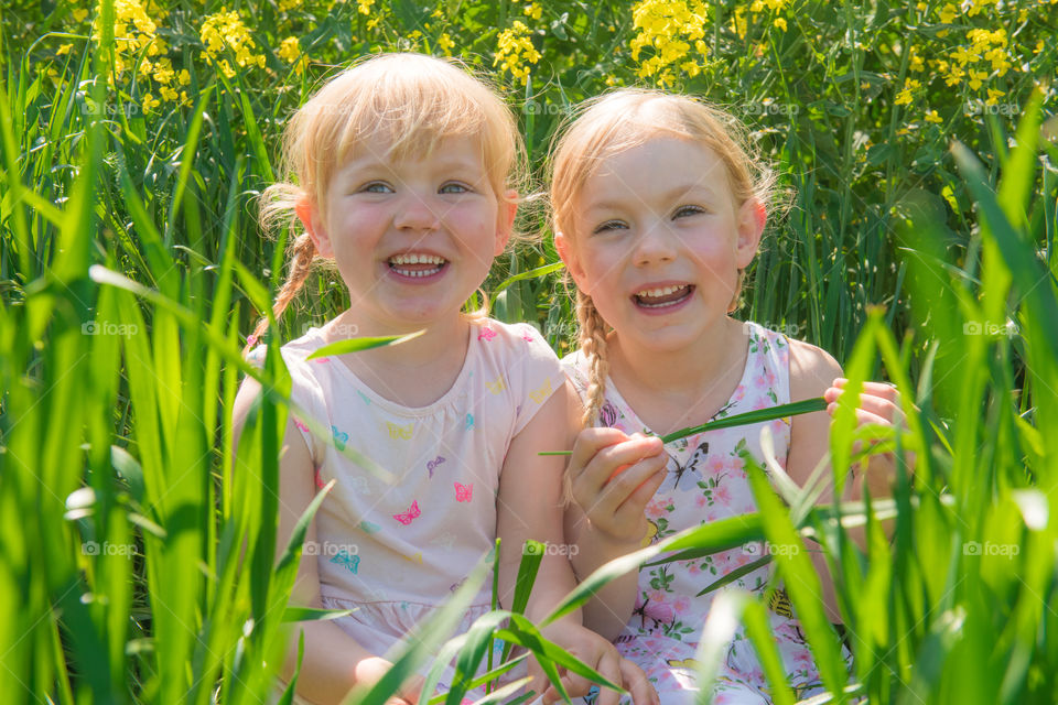 Portrait of happy sisters in field