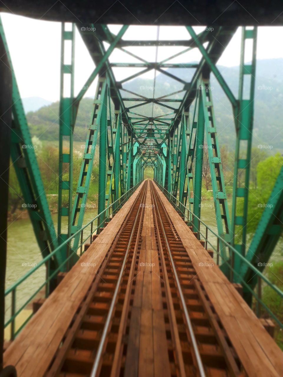 A view from the window of the last passenger wagon to the railway green bridge on the river of Bosna.