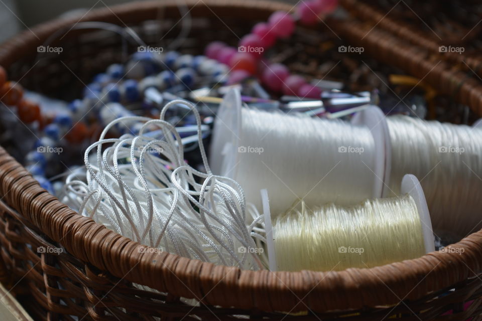 Spool and necklace in basket