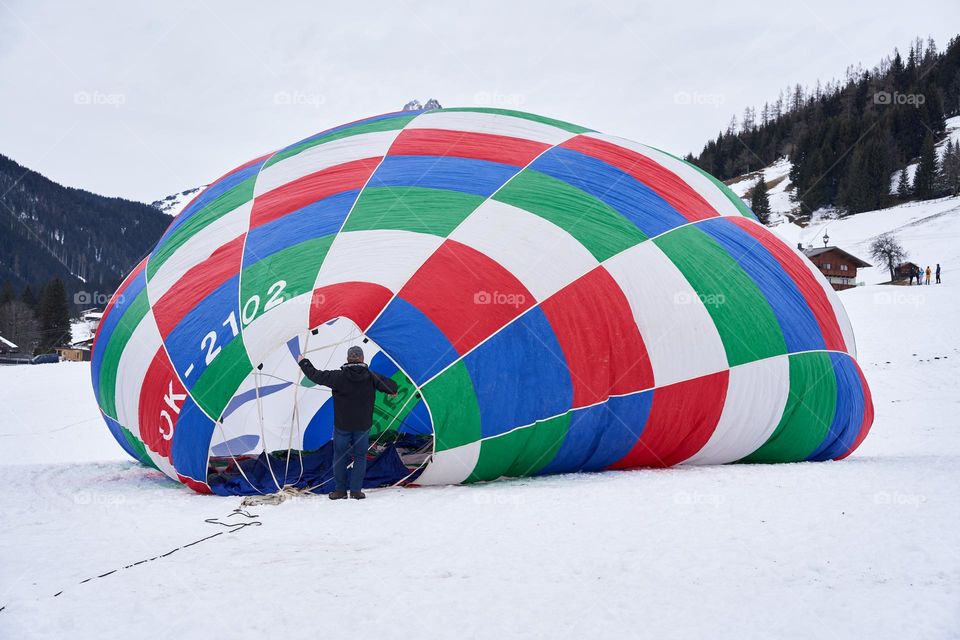 A man working hard to get the hot air balloon inflated 