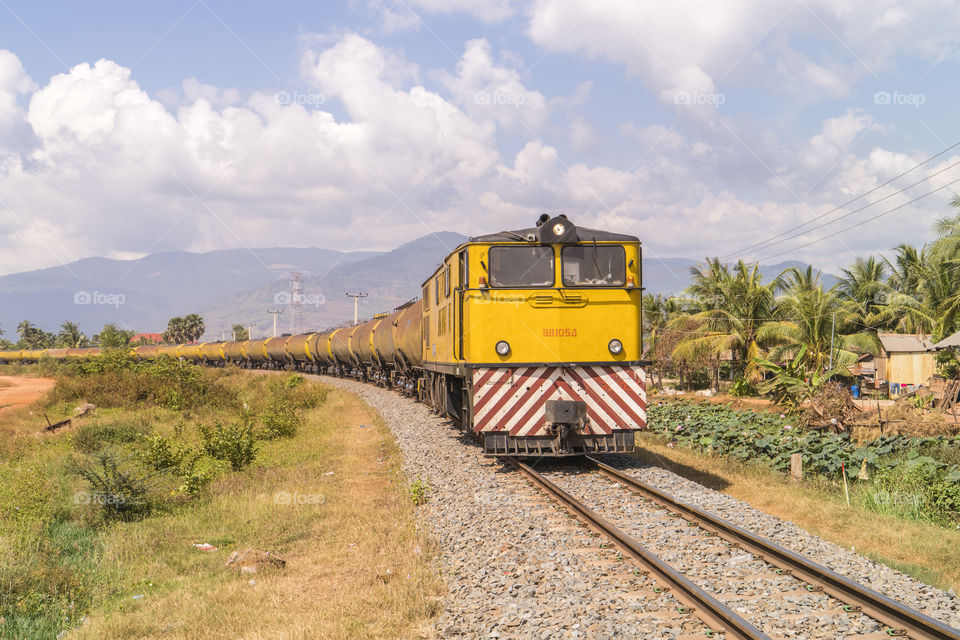 A yellow freight rain rolling on the railway in Kompot province, Cambodia 