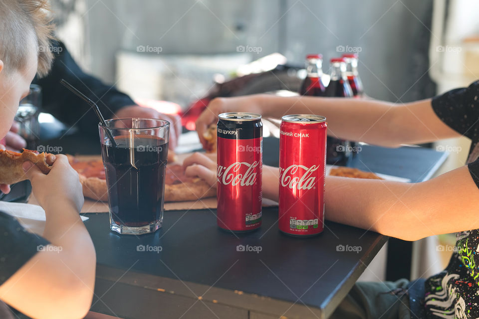 family eats, sit at the table, pizza and coca-cola. Grandfather and boys at the home