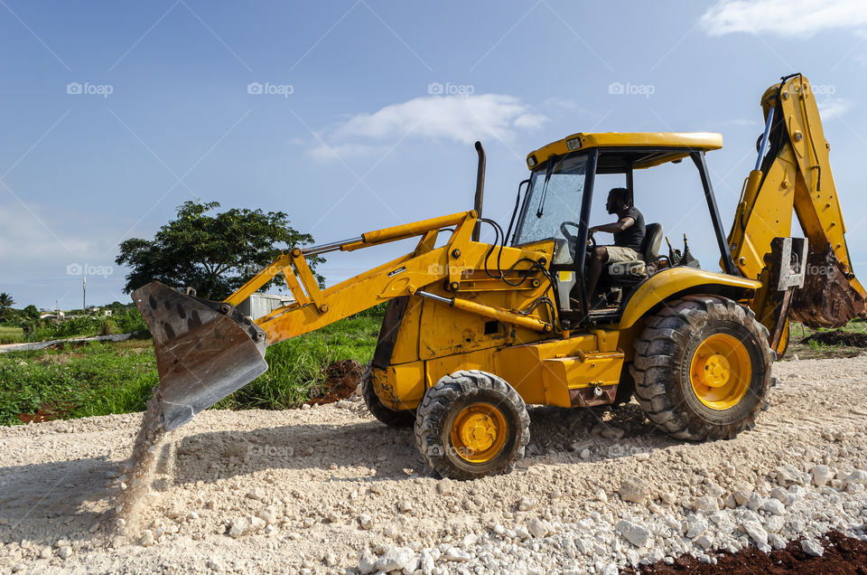 Jamaican Man Spreading Marl On New Road With Loader Bucket