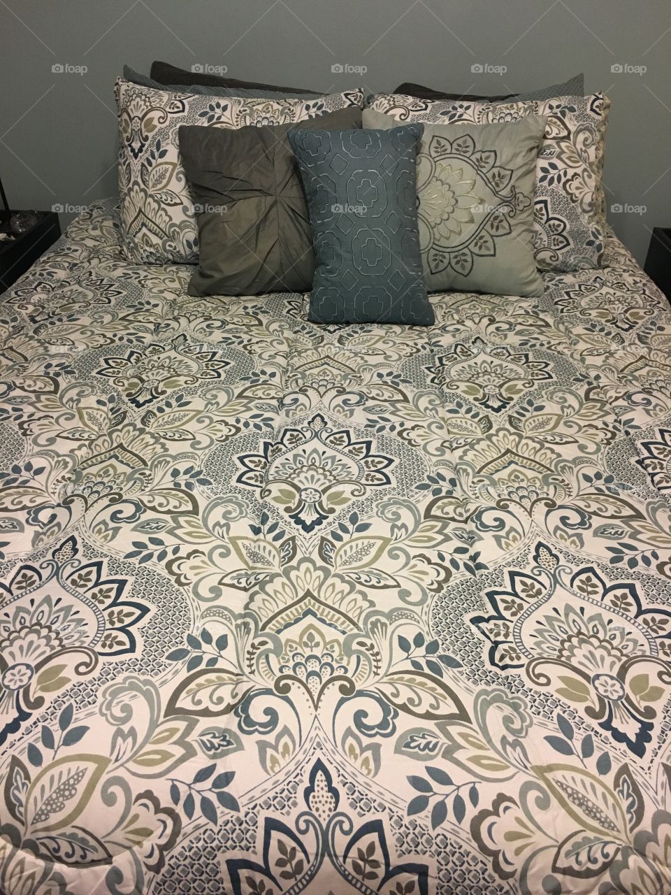 Whit and blue bedding with a ton of pillows